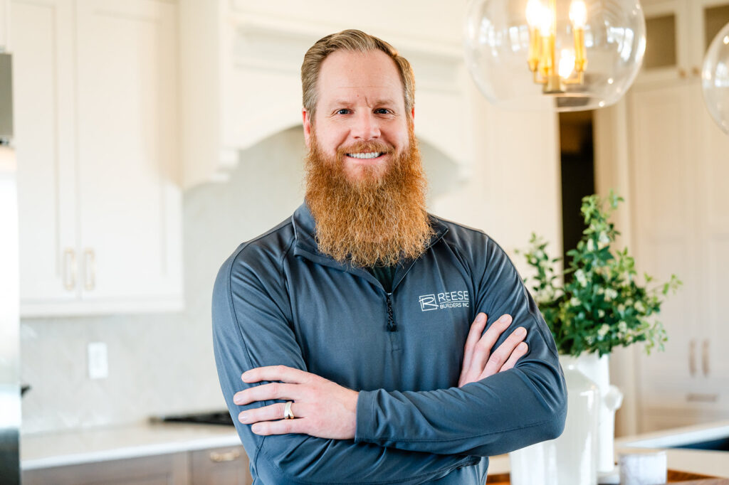 Luke Reese of Reese Builders standing proudly in front of a remodeled kitchen in Des Moines, Iowa